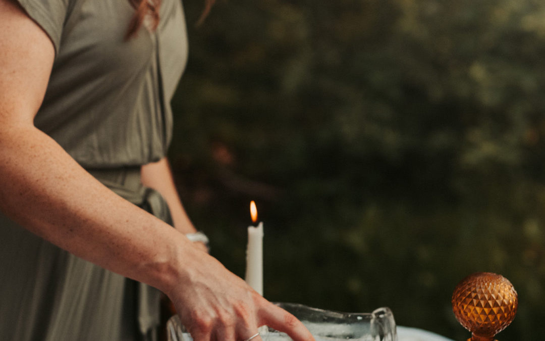 women pouring water on into glasses on an outdoor table scape