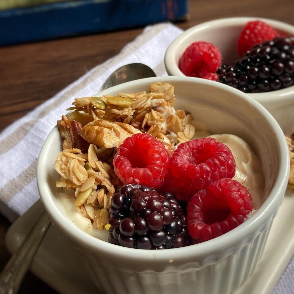 close up photos of two bowls filled with yogurt, berries and granola