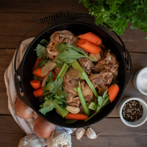 overhead shot of Cast iron pot with vegetable and bones with spices