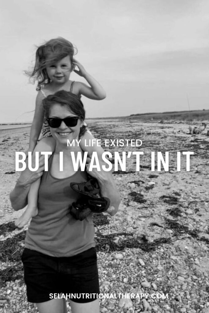 black and white folder of mother on beach with daughter on her shoulders