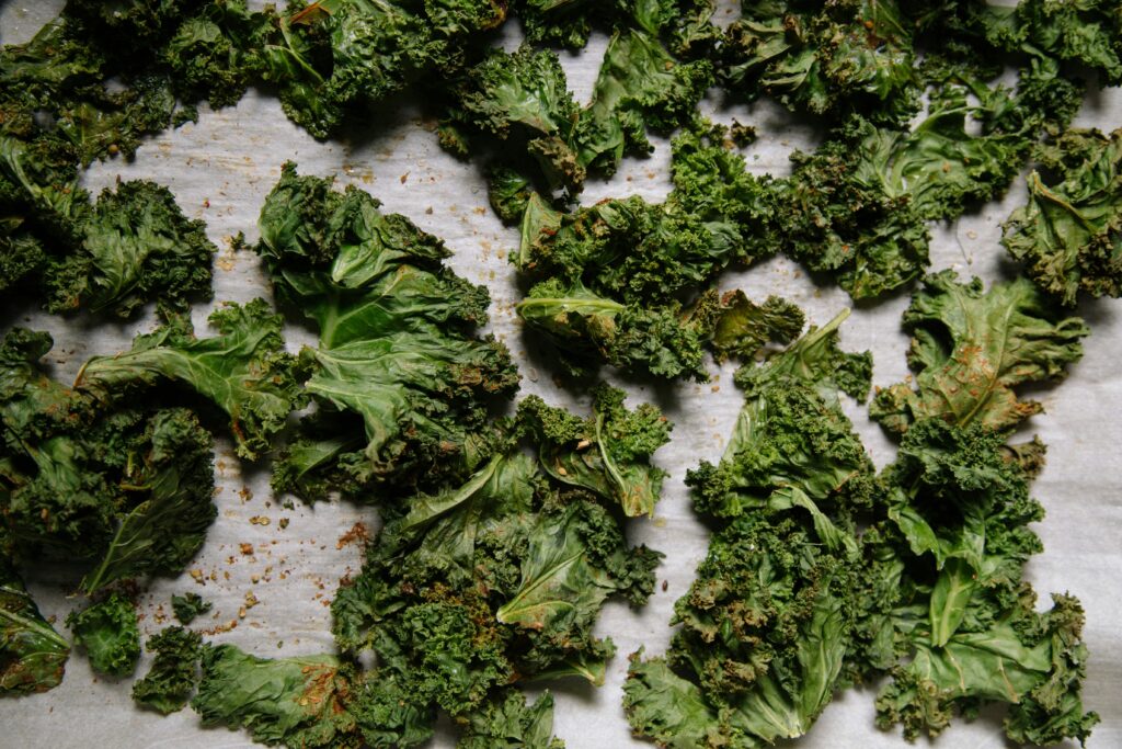 overhead shot of freshly made kale chips on parchment paper