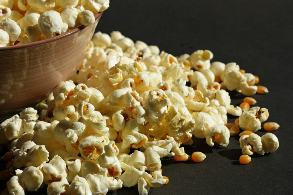 buttery yellow popcorn in a bowl spilling out onto the table