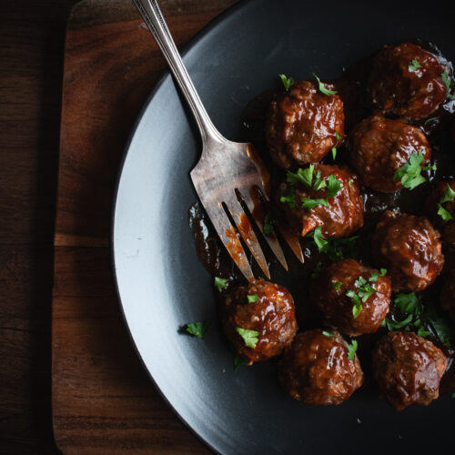 overhead shot of a plate of bbq meatballs with a fork