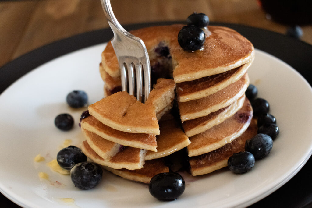 stack of pancakes with with a fork taking them apart