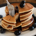 stack of pancakes with with a fork taking them apart