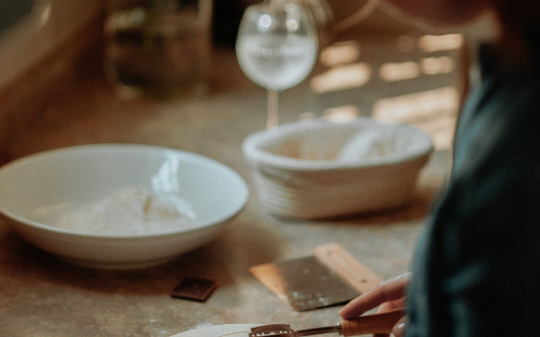 girl in kitchen scoring a bread loaf before baking