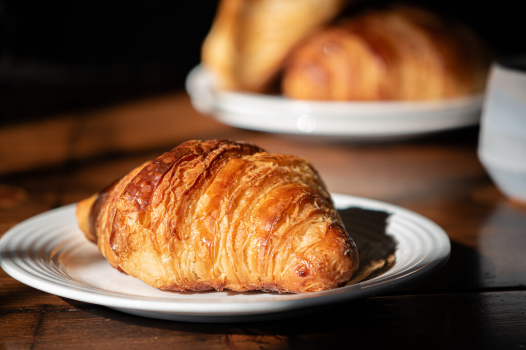 croissant on a plate with other croissants in background