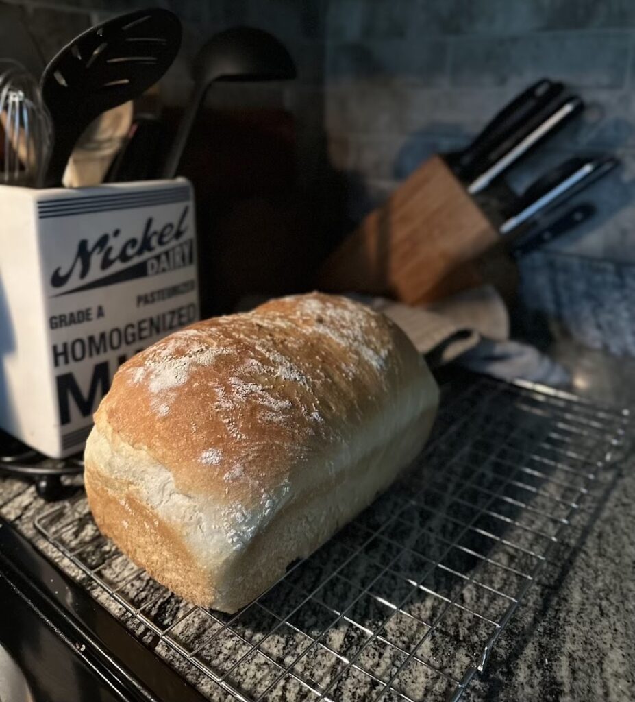 loaf of white sourdough sandwich bread on a kitchen counter at night