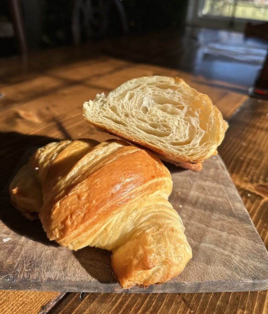 2 sourdough croissants on a table in the sunlight