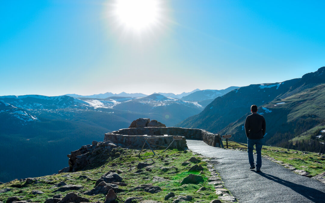 man walking out onto overlook at Rocky Mountains