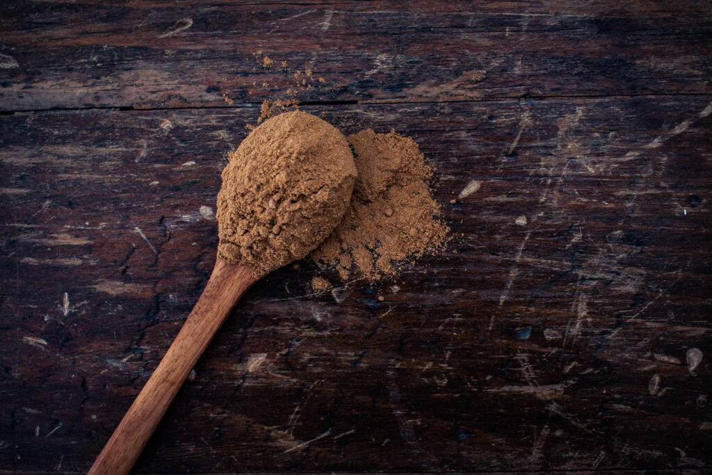 wooden spoon of mushroom coffee powder on a wooden table