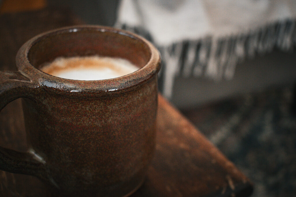 a ceramic mug full of a mushroom coffee latte