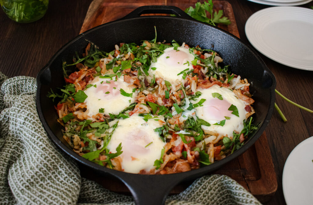 a mixed egg and potato breakfast dish in a cast iron skillet