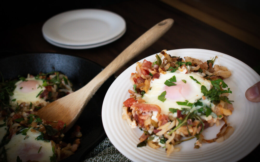 a egg and potato breakfast dish being scooped onto a plate