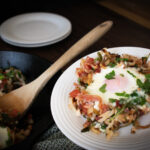 a egg and potato breakfast dish being scooped onto a plate