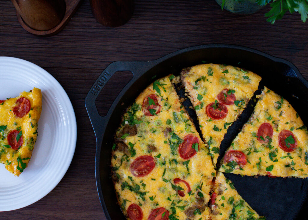 overhead shot of a skillet frittata with a piece taken out
