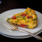 piece of frittata on a plate with a fork